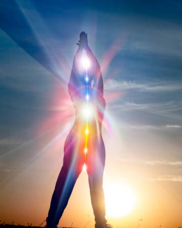 woman in yoga pose on beach sunset view, glowing seven all chakra. Kundalini energy. girl practicing meditation outdoors. Silhouette.